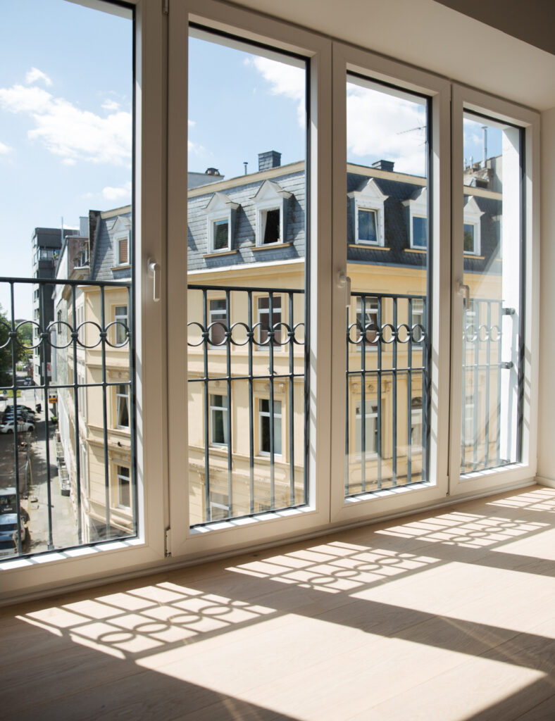 Holzfußboden in einem Mietstudio mit schönem Blick durch die Fenster auf die Umgebung.