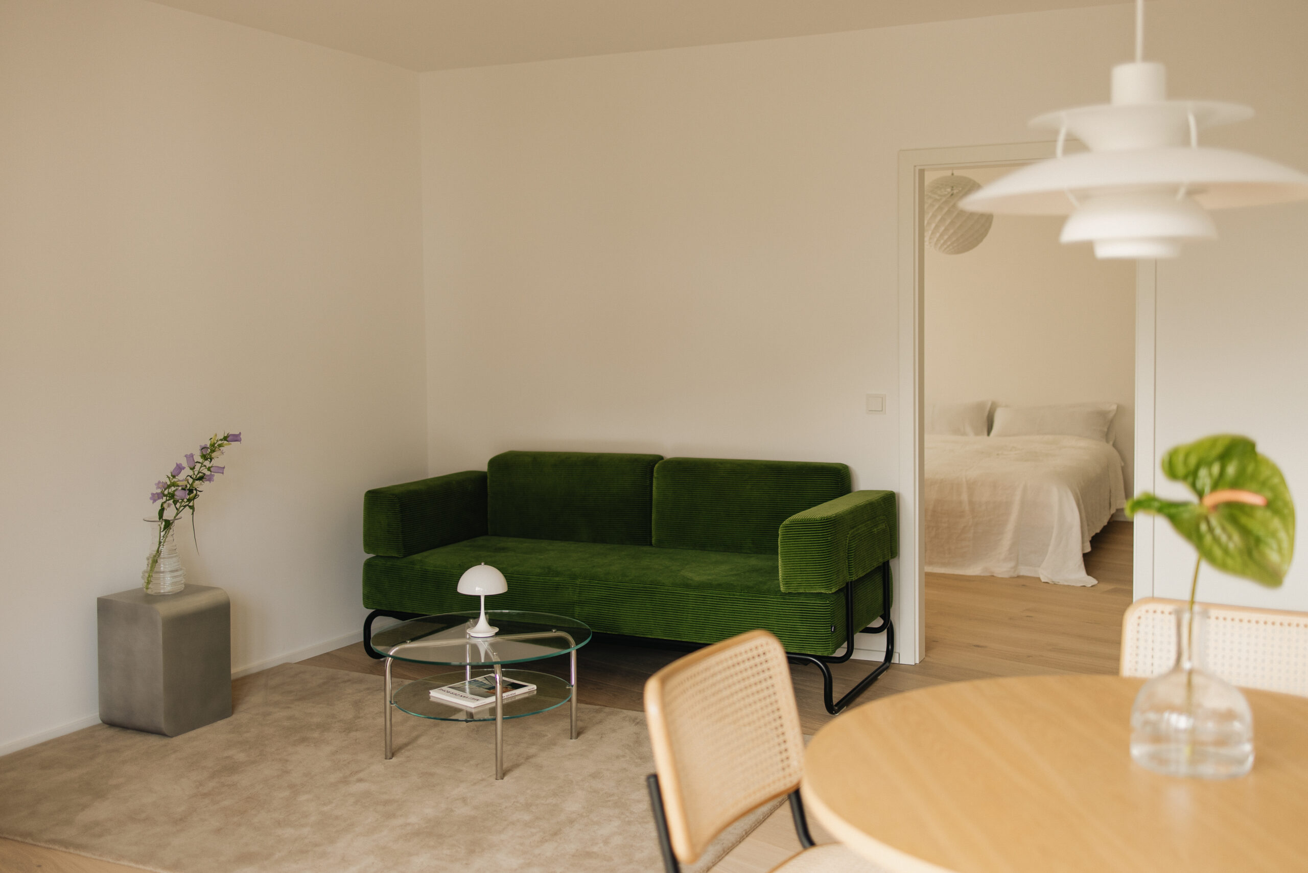 Gemütliches Wohnzimmer mit einer grünen Couch in einem stilvollen Mietstudio.